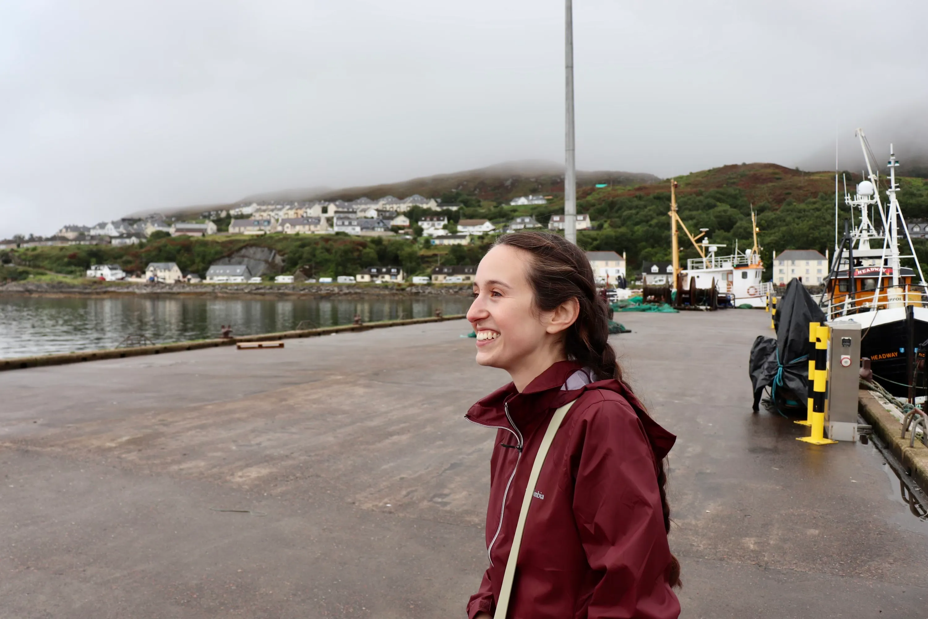 Steph Knapp smiling on a harbour pier in the Scottish Highlands